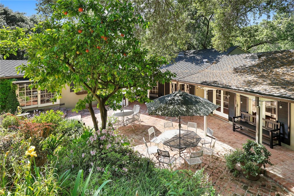 8 Hidden Valley Road Monrovia, CA 91016 - Photo 10 of 45 a backyard of a house with table and chairs under an umbrella