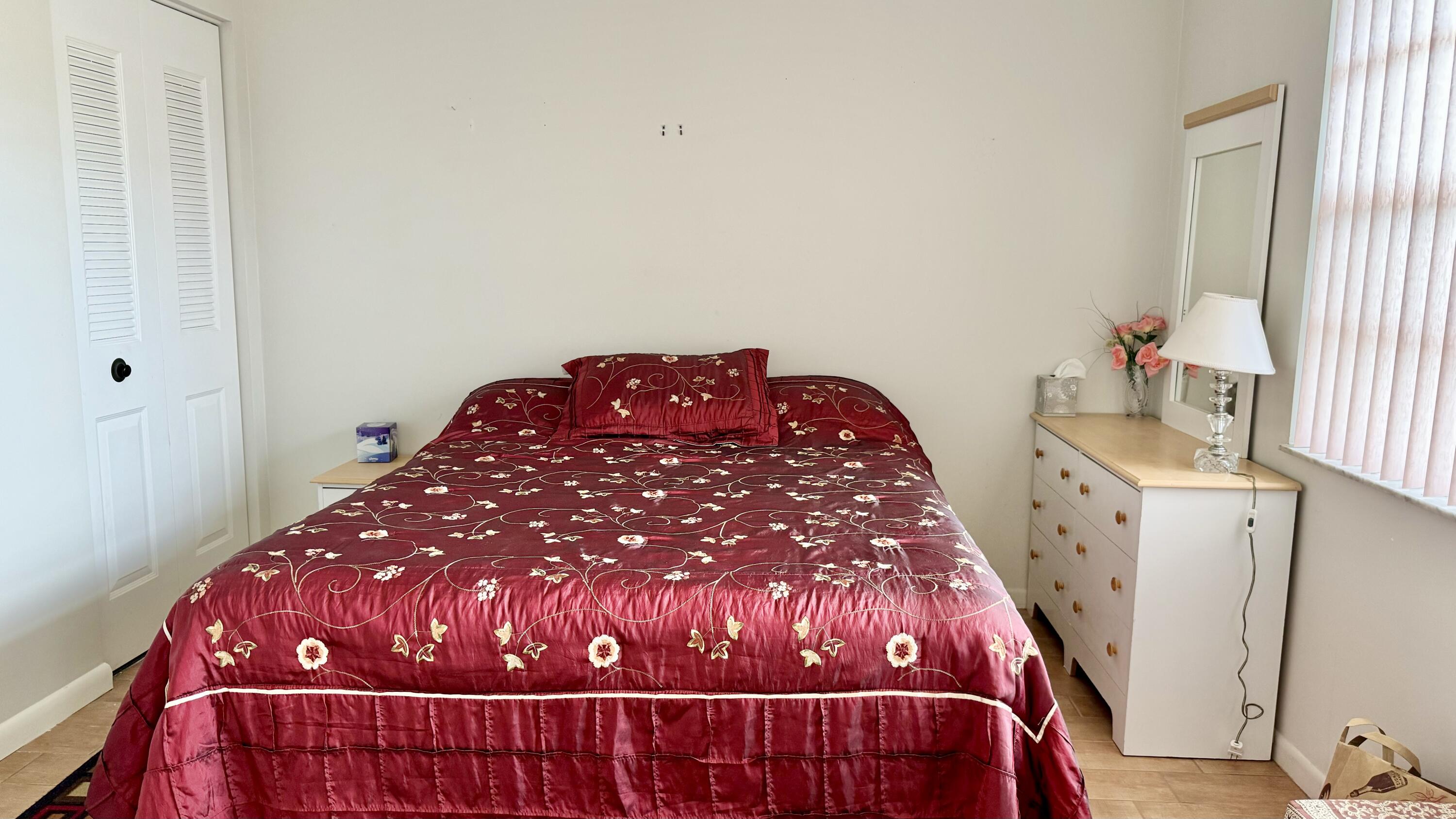 1551 Northwest 20th Avenue, Unit 102 Delray Beach, FL 33445 - Photo 12 of 18 a bedroom with a bed and a window