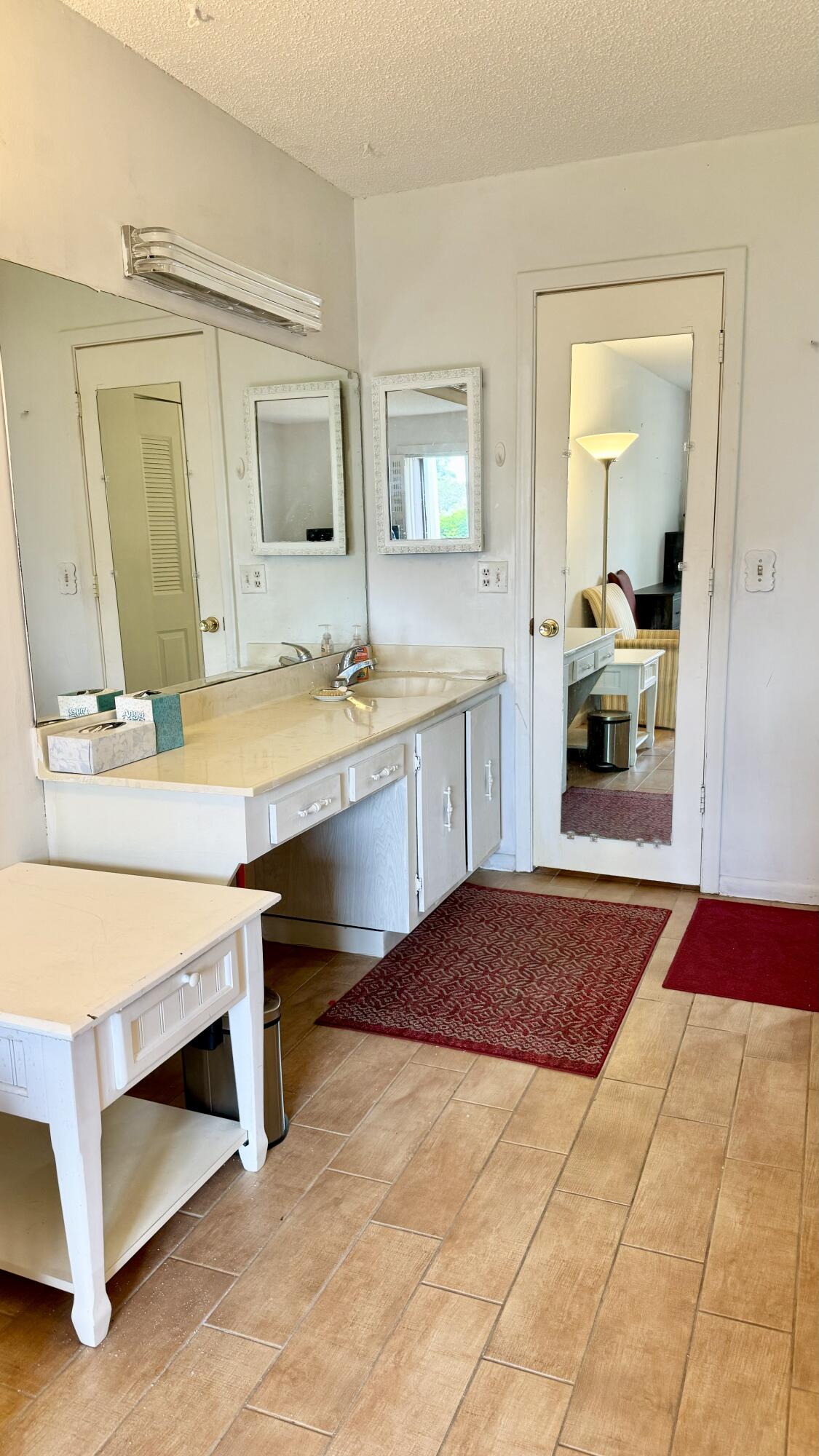 1551 Northwest 20th Avenue, Unit 102 Delray Beach, FL 33445 - Photo 14 of 18 a bedroom with a bed and a dresser