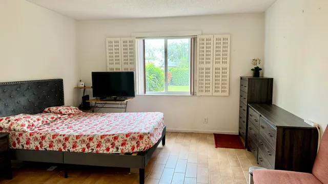 a bed sitting in a bedroom next to a window