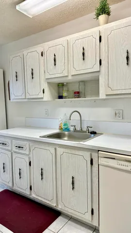 a kitchen with white cabinets and sink