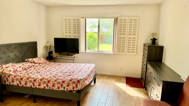 a bed sitting in a bedroom next to a window