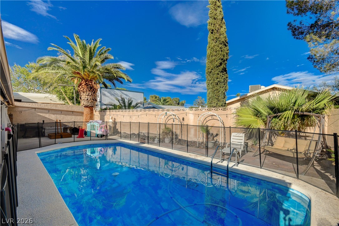 659 Arrayo Way Boulder City, NV 89005 - Photo 23 of 29 Mature palms and a safety fence frame this sparkling backyard swimming pool.