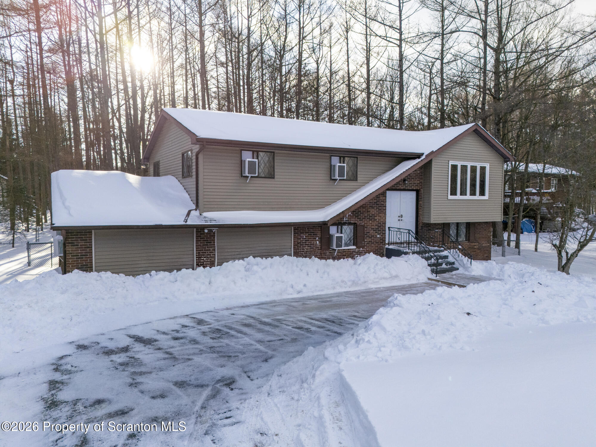a front view of a house with a yard covered in snow