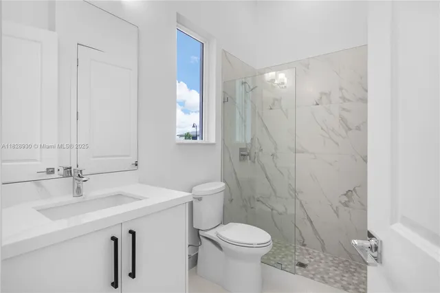 a white toilet sitting next to a bathroom sink