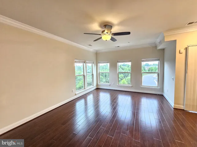 a view of room with window ceiling fan and hardwood floor