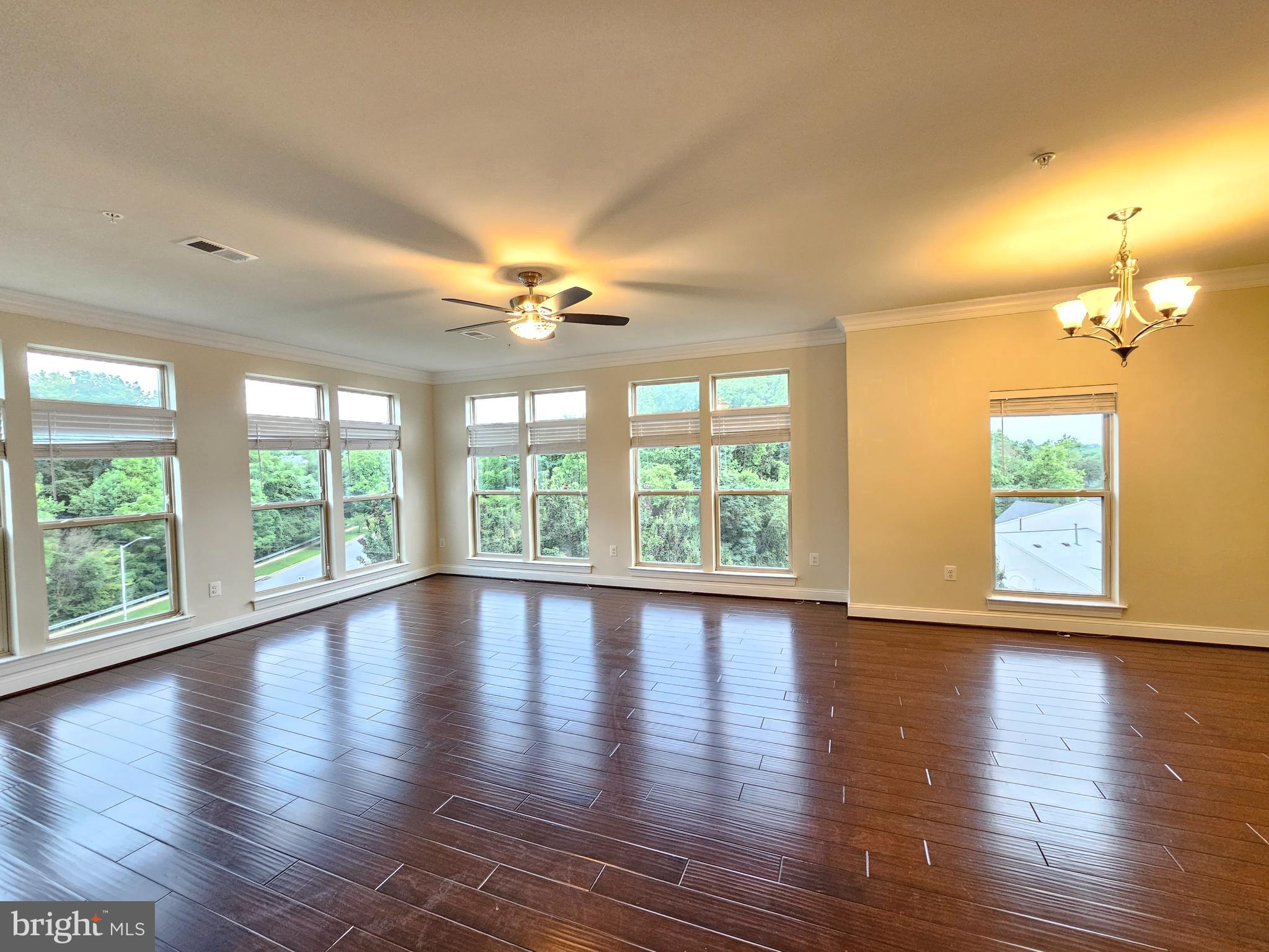 164 Copley Circle, Unit 27B Gaithersburg, MD 20878 - Photo 8 of 34 a view of an empty room with wooden floor and a window