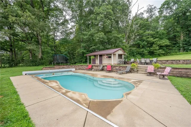 a swimming pool with outdoor seating and yard