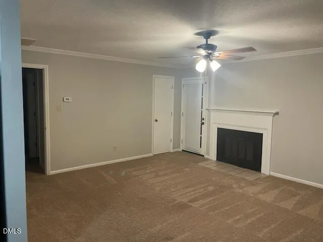 en empty room with a ceiling fan and a fireplace