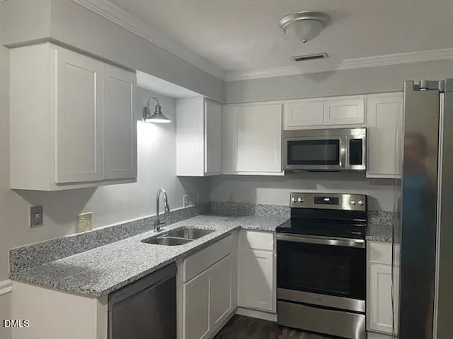 a kitchen with stainless steel appliances granite countertop a sink stove and microwave
