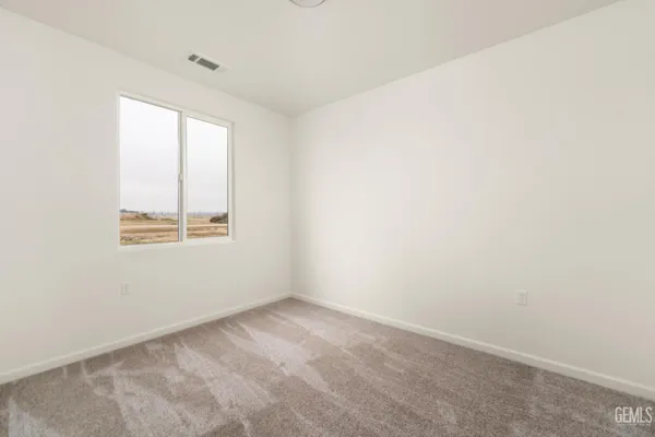 an empty room with a bathroom and a mirror