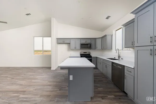 a kitchen with a sink a counter top space and cabinets