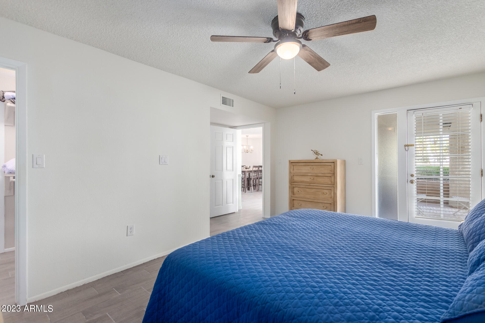 709 South Power Road, Unit 105 Mesa, AZ 85206 - Photo 11 of 36 a bedroom with a large bed and a chandelier fan