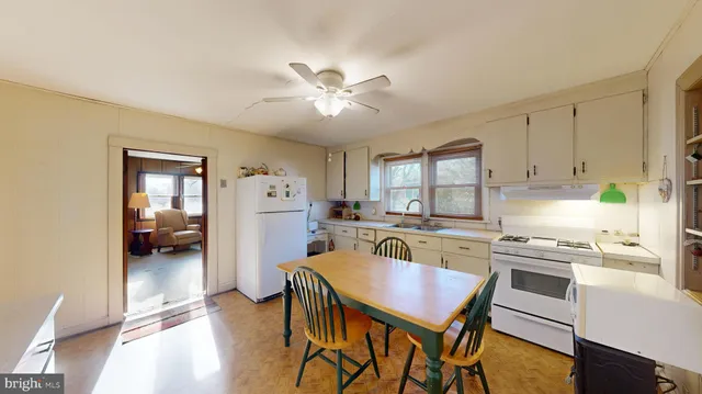 a kitchen with a table chairs refrigerator and cabinets