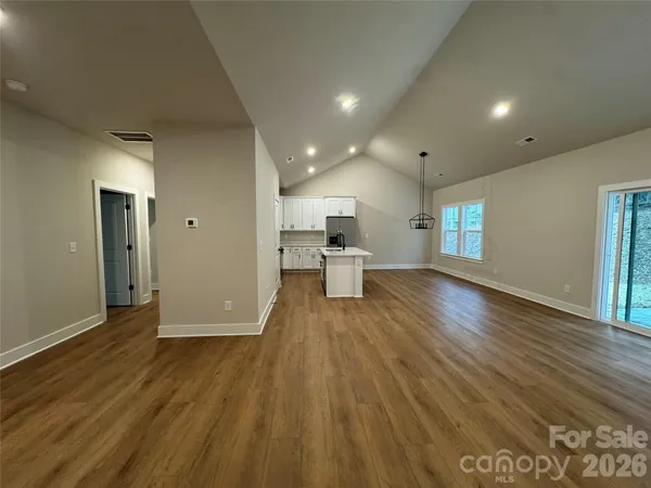 a view of a big room with wooden floor and windows