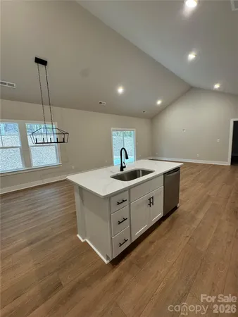 a kitchen with stainless steel appliances granite countertop a sink a oven a counter space and cabinets