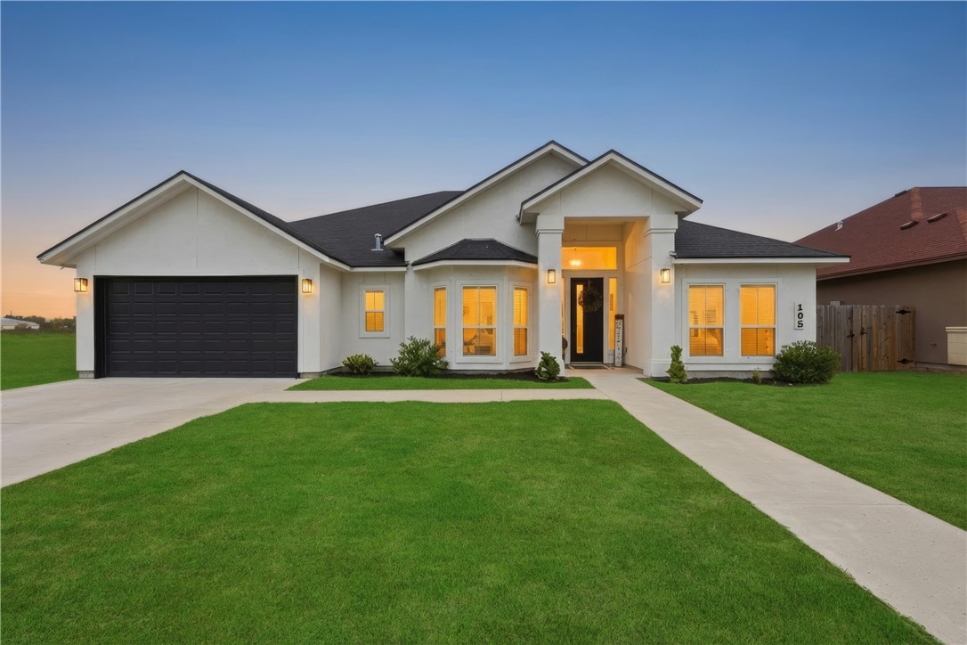 a front view of a house with a yard and garage