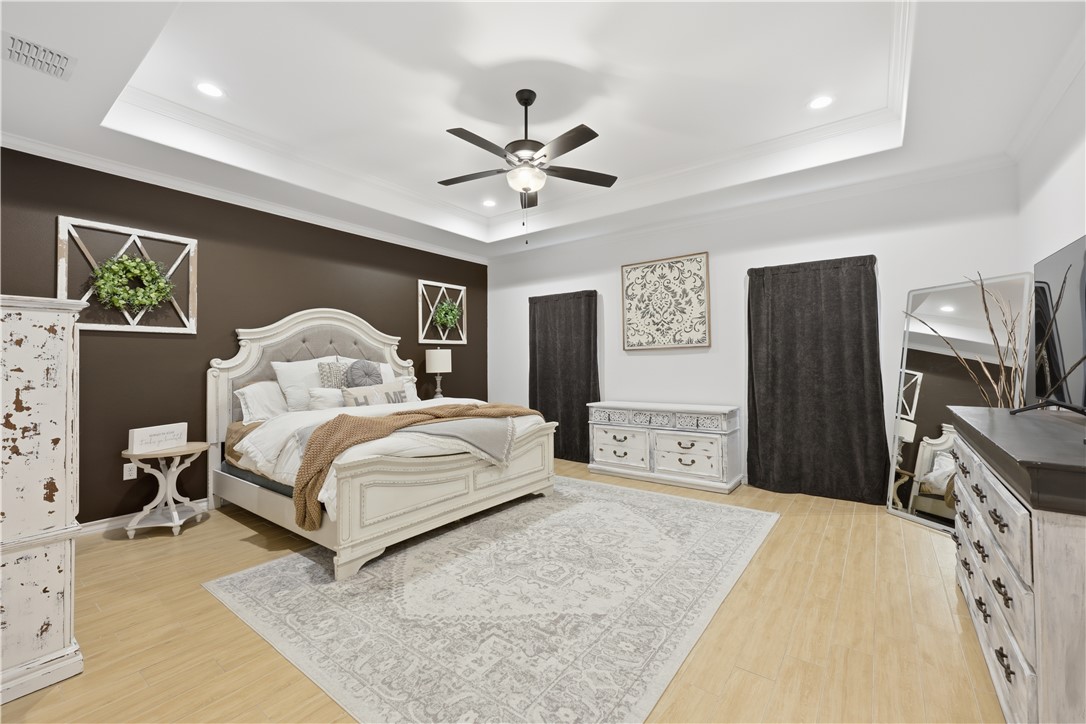 105 Sapphire Street Portland, TX 78374 - Photo 17 of 29 a bedroom with a large bed and a chandelier