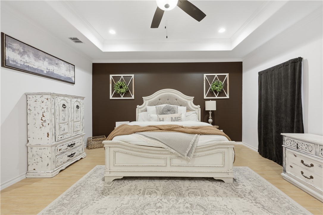 105 Sapphire Street Portland, TX 78374 - Photo 18 of 29 a bedroom with a bed and a flat tv screen on dresser