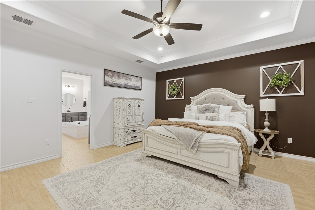 105 Sapphire Street Portland, TX 78374 - Photo 20 of 29 a bedroom with a large bed and a chandelier