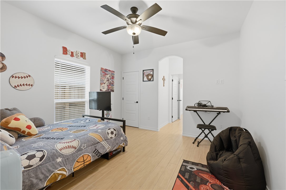 105 Sapphire Street Portland, TX 78374 - Photo 25 of 29 a bedroom with a bed and a chandelier