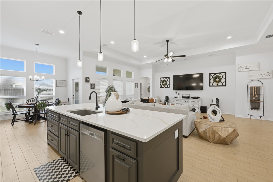 105 Sapphire Street Portland, TX 78374 - Photo 10 of 29 a kitchen with stainless steel appliances kitchen island granite countertop a sink and a flat screen tv