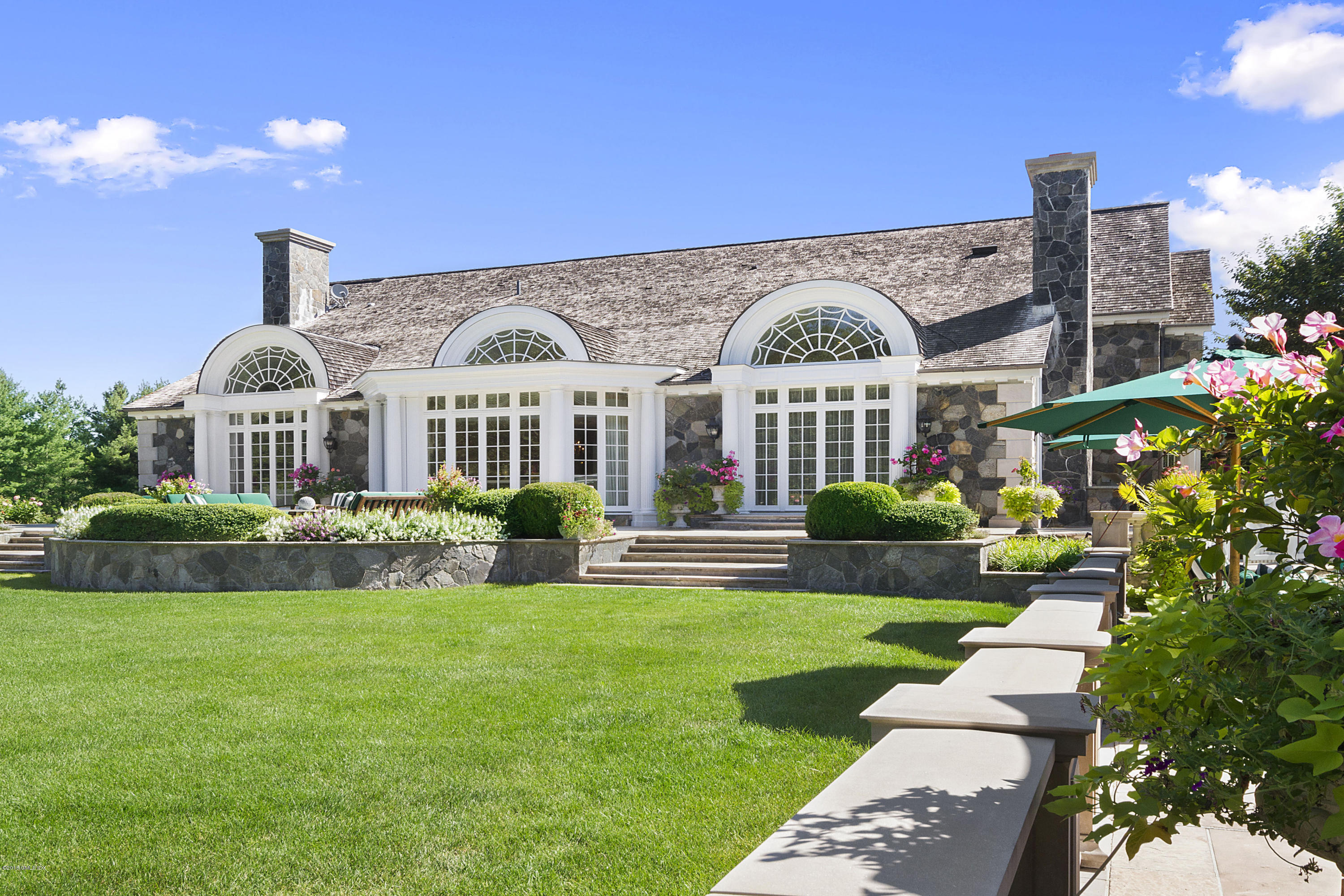 20 Andrews Farm Road Greenwich, CT 06831 - Photo 33 of 39 a front view of a house with a garden and plants