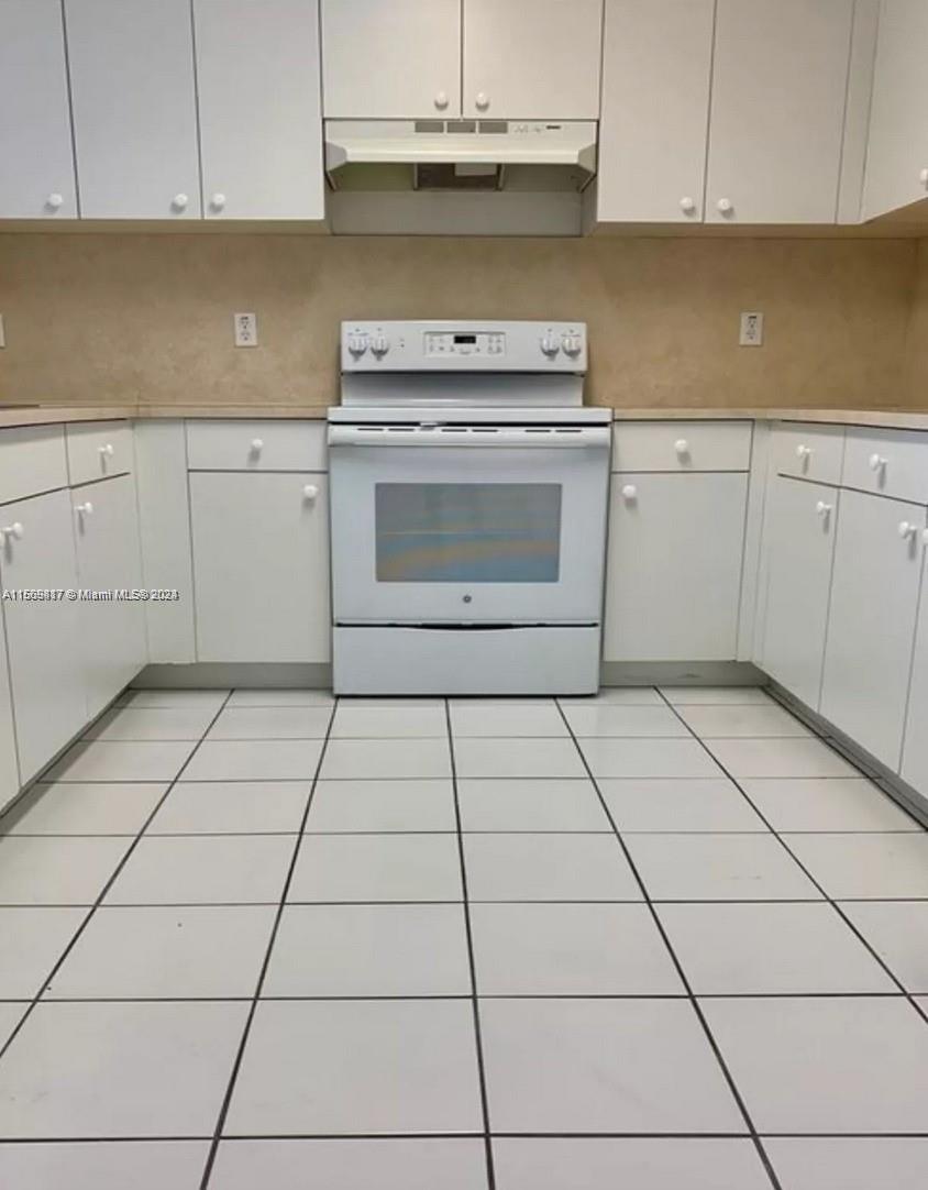 a kitchen with a stove a sink and cabinets