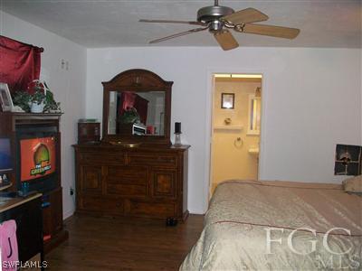 17464 Lee Road Fort Myers, FL 33967 - Photo 8 of 10 a bedroom with a bed and a fireplace
