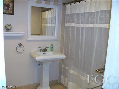 17464 Lee Road Fort Myers, FL 33967 - Photo 10 of 10 a bathroom with a sink a mirror and a shower