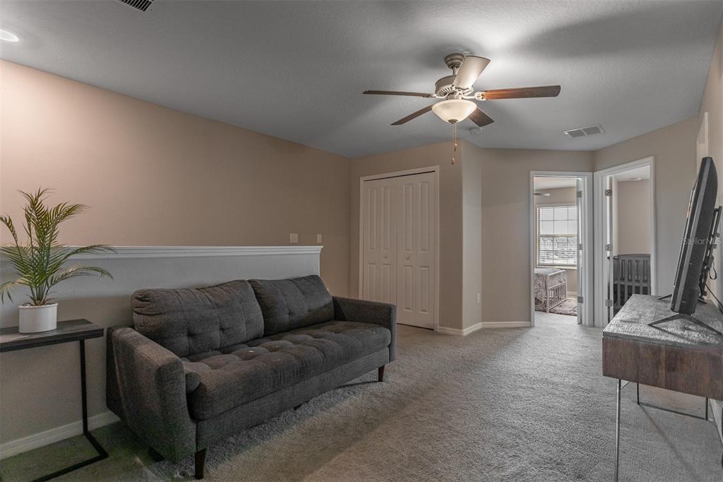 14206 Easy Goer Street Ruskin, FL 33573 - Photo 11 of 28 a living room with furniture and a chandelier