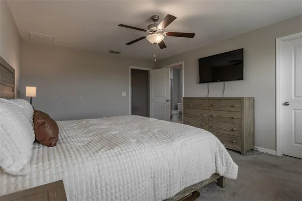 a bedroom with a bed and a flat screen tv