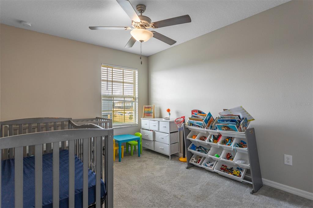 14206 Easy Goer Street Ruskin, FL 33573 - Photo 21 of 28 a bedroom with baby crib and a window