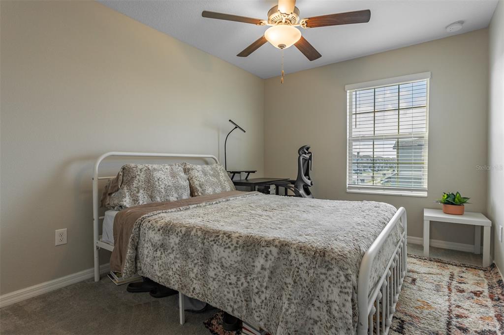 14206 Easy Goer Street Ruskin, FL 33573 - Photo 22 of 28 a bedroom with a bed and a chandelier