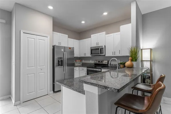 a kitchen with stainless steel appliances granite countertop a stove refrigerator and cabinets