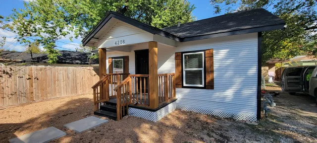 a view of a house with a yard and wooden fence