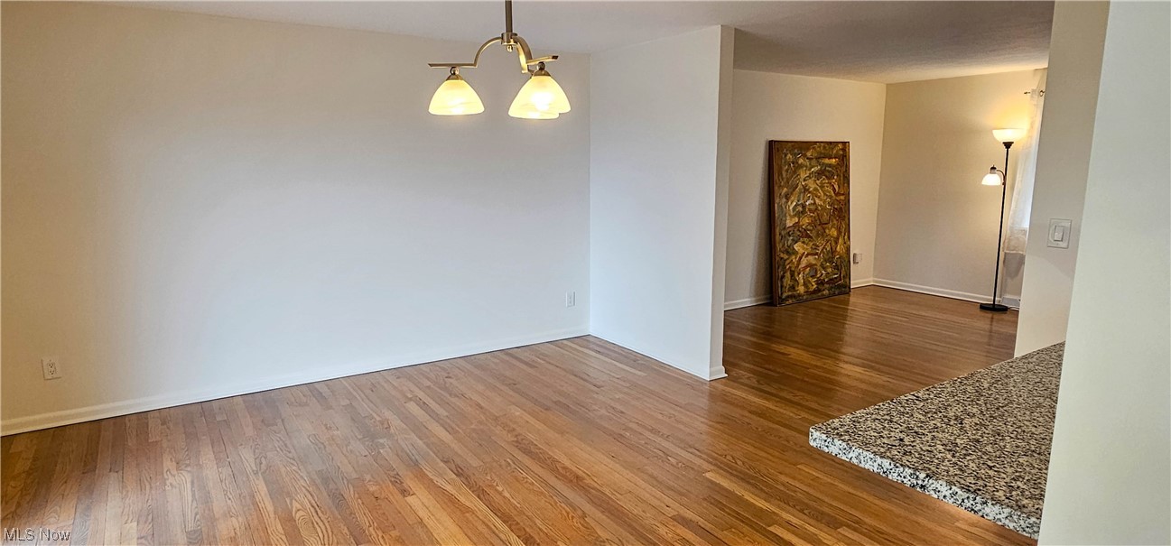 19755 Upper Terrace Road Euclid, OH 44117 - Photo 19 of 38 Spare room featuring a chandelier and dark wood-type flooring