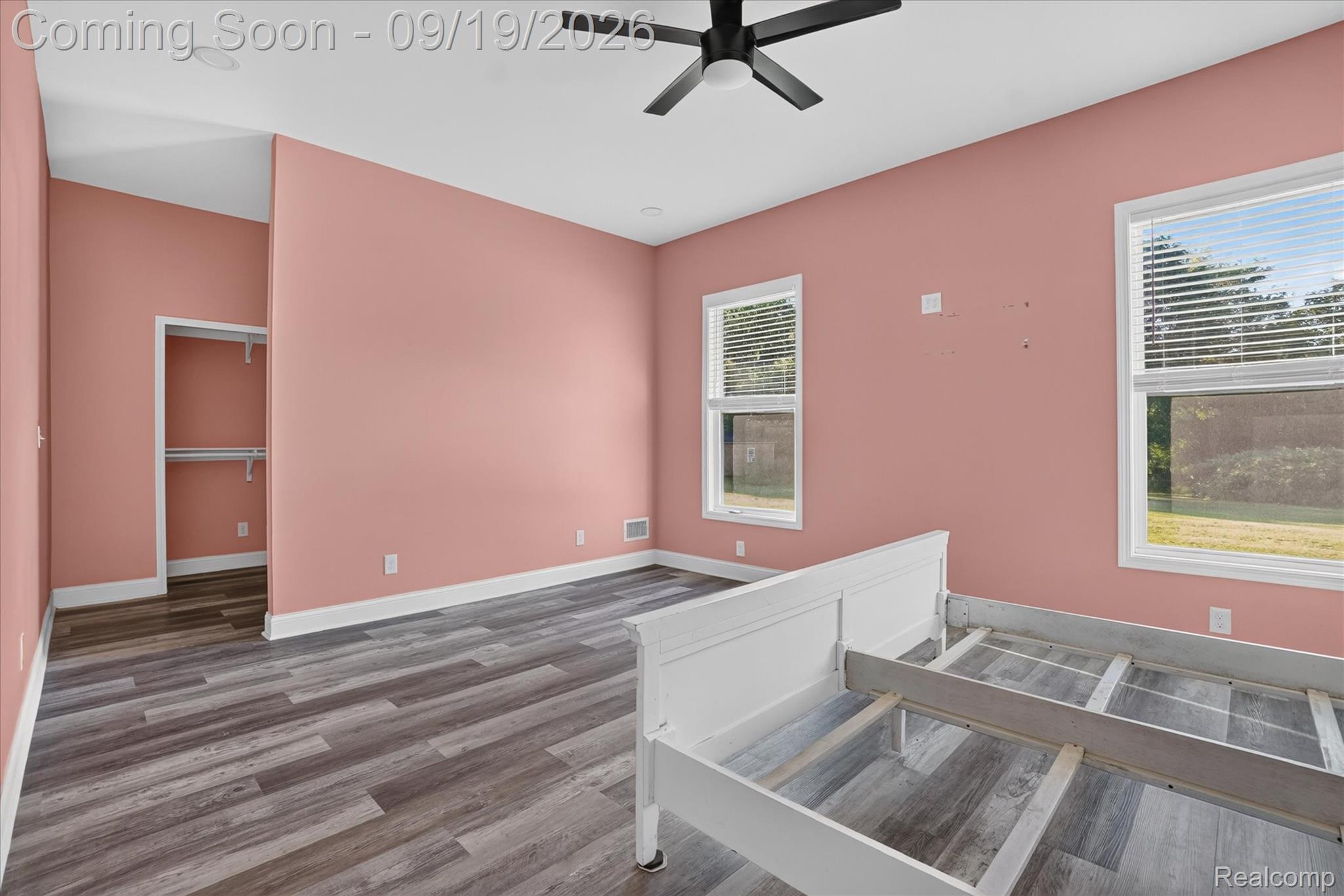 10215 West Mount Morris Road Flushing, MI 48433 - Photo 29 of 58 Wood-finish flooring, two large windows with blinds, a ceiling fan, and a built-in closet with shelving
