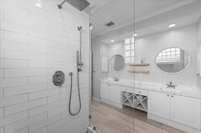 a bathroom with a double vanity sink mirror and window