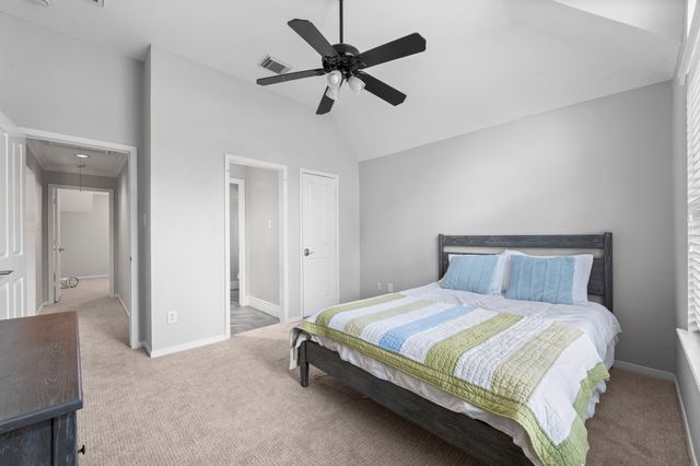 a bedroom with a bed and a ceiling fan