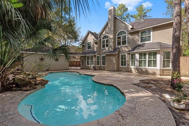 a view of a white house with a yard and potted plants