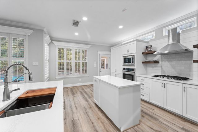 a kitchen with stainless steel appliances granite countertop a stove and a sink