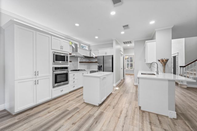 a kitchen with stainless steel appliances a refrigerator sink and microwave