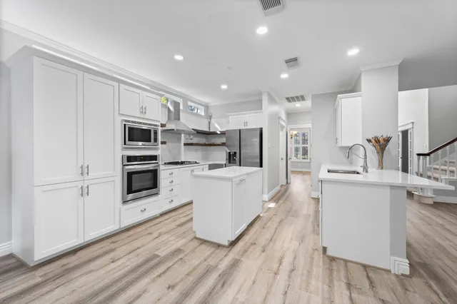 a kitchen with stainless steel appliances a refrigerator sink and microwave