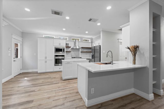 a kitchen with stainless steel appliances a sink stove and cabinets