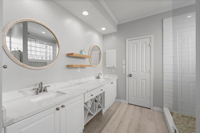 a spacious bathroom with a double vanity sink a mirror and shower