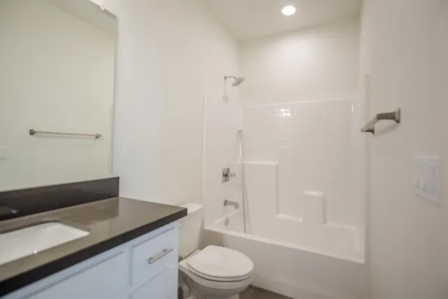 a view of a kitchen with white cabinets and a window