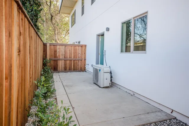a view of a white house with large windows and a small yard