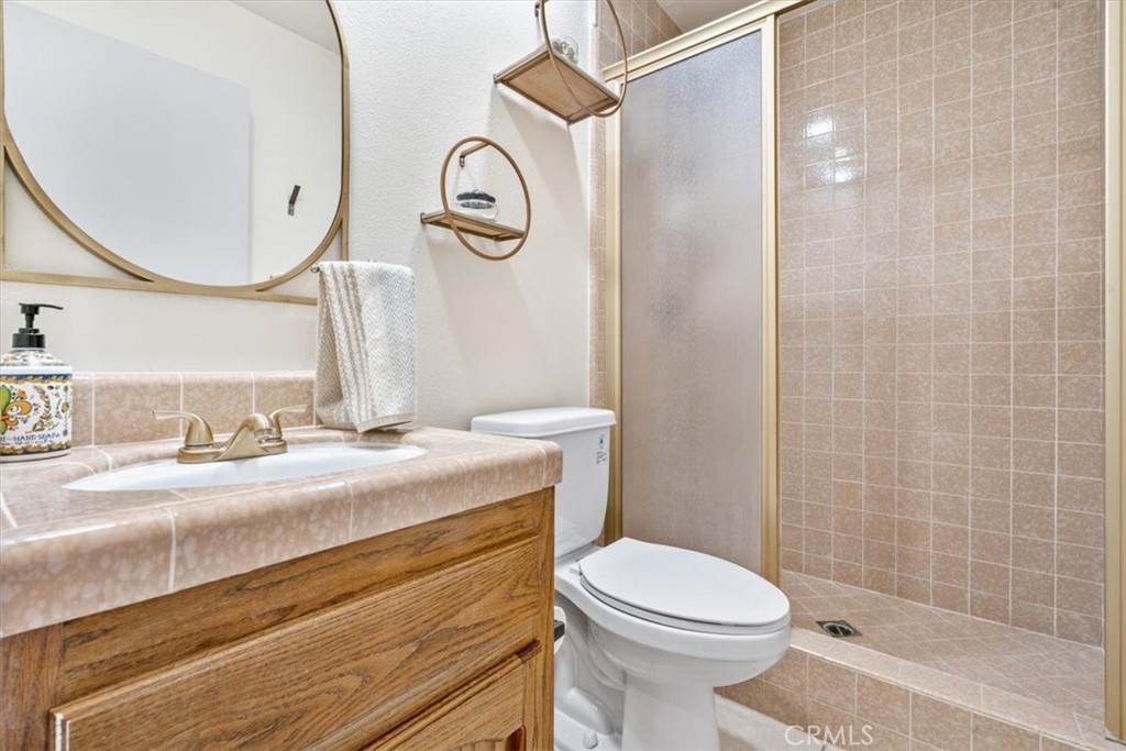 284 Spruce Street Arroyo Grande, CA 93420 - Photo 13 of 31 a bathroom with a granite countertop sink toilet and a mirror