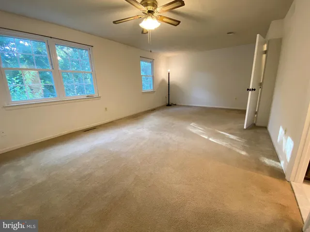 an empty room with a empty space and a ceiling fan